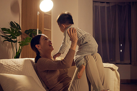 夜晚趴在床上夜晚妈妈陪伴宝宝玩耍背景