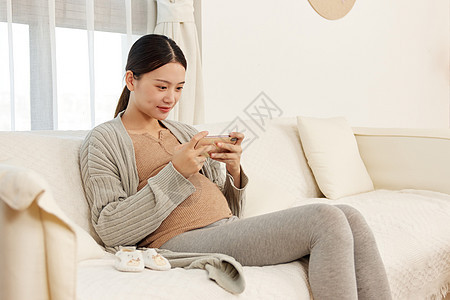 孕妈居家玩手机游戏背景图片