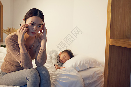 孩子睡着后情绪烦躁打电话的妈妈图片