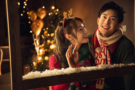 圣诞浪漫可爱的幸福情侣看向窗外图片