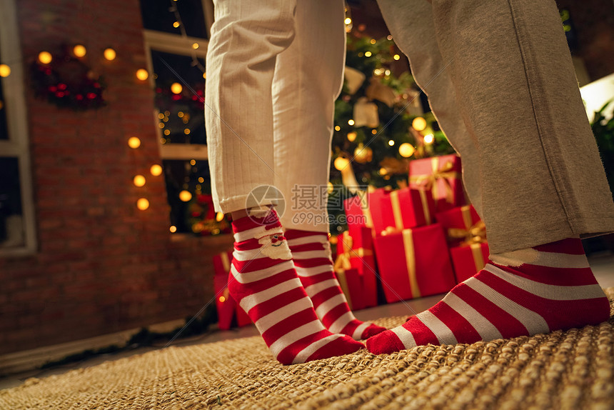 红色舒适青年人穿着圣诞情侣袜的脚部特写图片