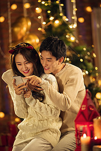 青年男人女人微笑幸福的年轻伴侣在家玩手机图片