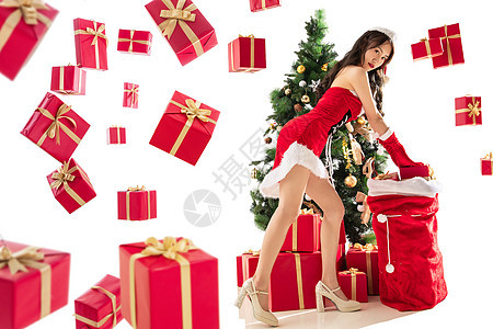 庆祝圣诞树享乐穿着圣诞服的年轻女人和圣诞礼物图片