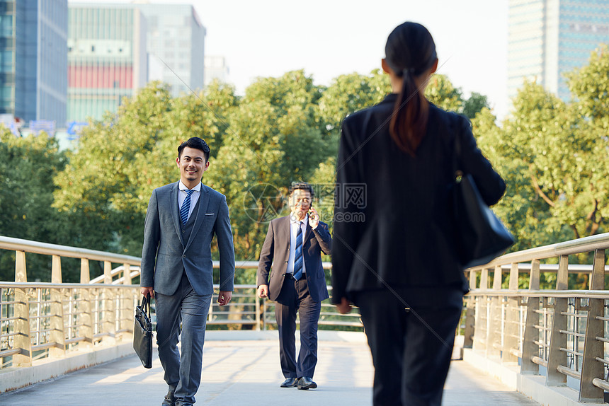 商务人士通勤路上交错行走图片