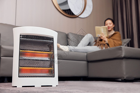 空调取暖使用取暖器过冬的居家女性背景