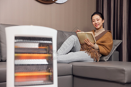 青年女性使用取暖器过冬图片