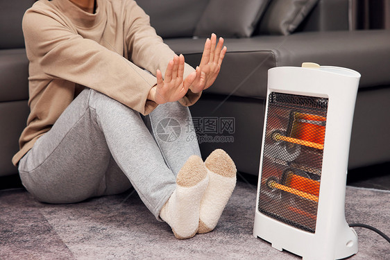居家女性使用取暖器特写图片
