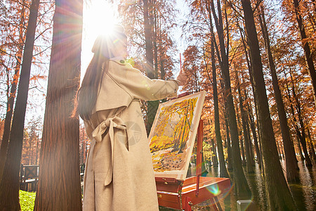 秋冬美女户外森林里作画图片