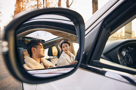 反光镜中情侣坐在汽车内图片