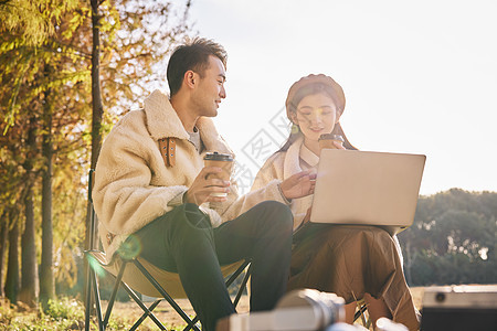 年轻情侣坐在户外休闲放松图片