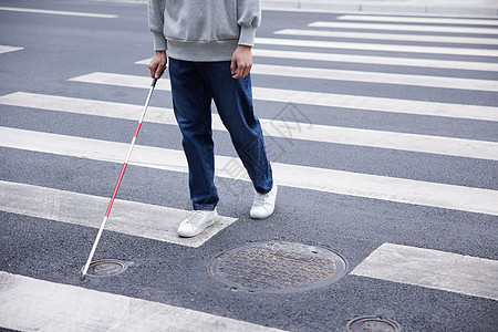 使用盲杖探路过马路的视盲青年图片