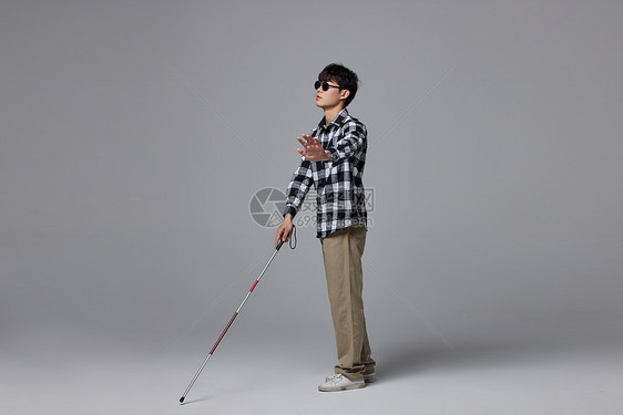 青年盲人出行使用盲杖图片