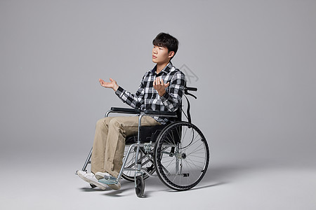 青年男性坐轮椅无奈形象图片