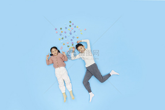 躺在地上的儿童和彩色字母图片