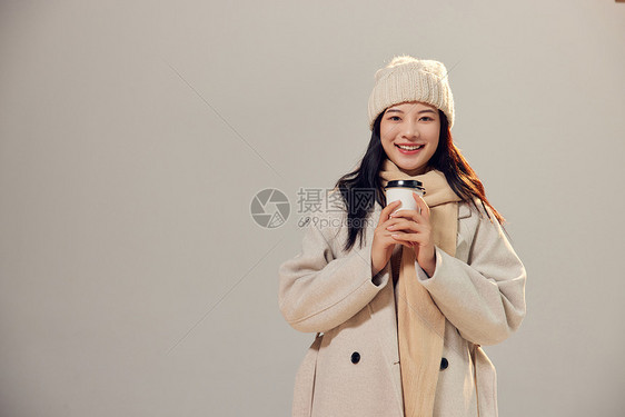 冬季美女拿着咖啡杯暖手图片