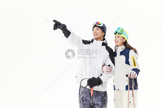 年轻情侣一起滑雪手指前方图片