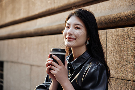 青年女性街头手拿咖啡形象图片