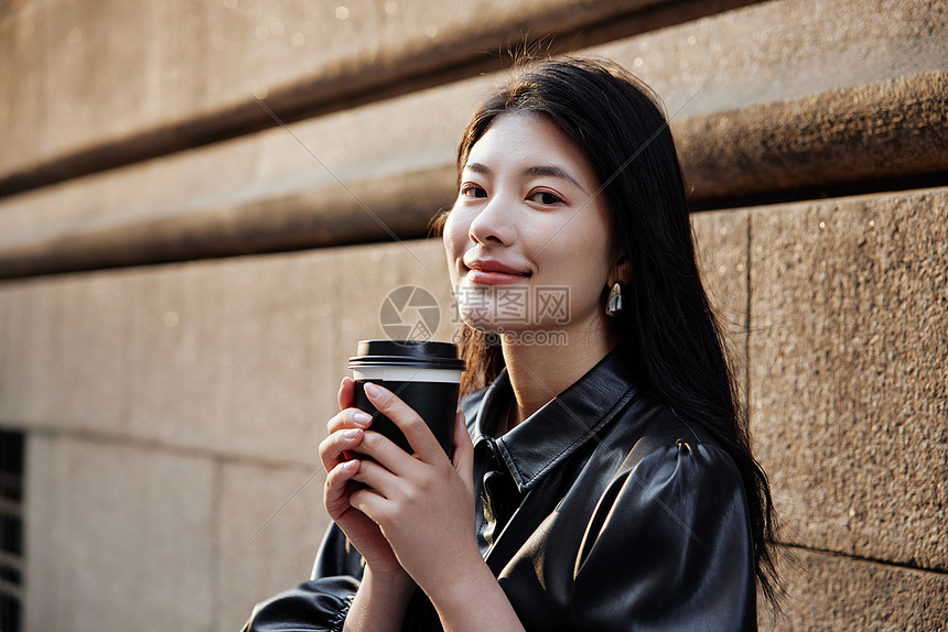 青年女性街头手拿咖啡形象图片