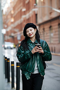 手拿咖啡的青年女性街头街拍图片