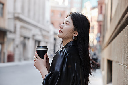 街头酷女孩手拿咖啡的时尚美女背景