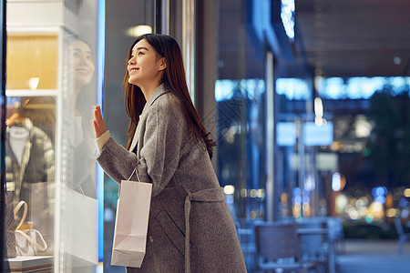 冬日女性夜晚逛街看橱窗图片