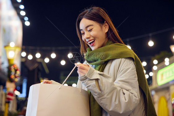 青年女性手拿战利品开心形象图片