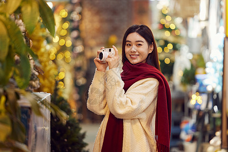 圣诞节甜美女性手拿相机的青年女性形象背景