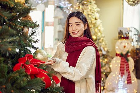在圣诞集市采购圣诞装饰的青年女性图片