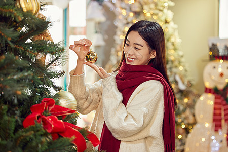 在圣诞集市采购圣诞装饰的青年女性图片