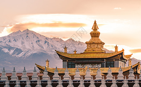 赛里木雪山夕阳下的雪山与寺庙背景