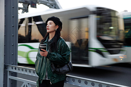 单脚着地酷女孩手拿咖啡的时尚街头女孩背景