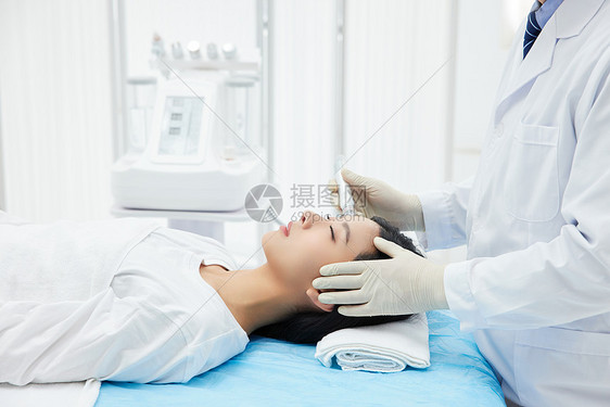 医生给美女顾客做面部医美护理图片