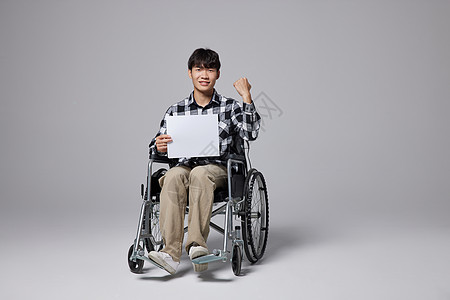青年男性坐轮椅手拿白板励志形象图片