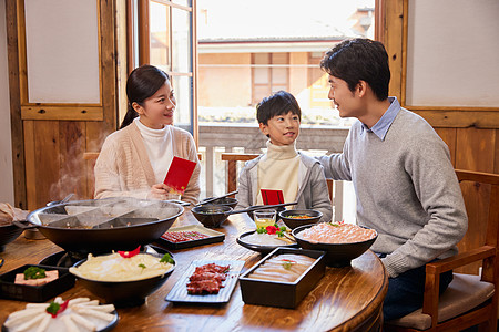 火锅店吃火锅发红包的新年家庭图片