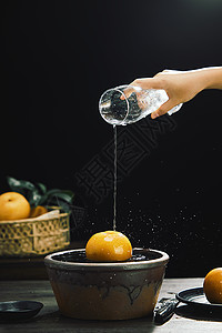 手拿水杯将水倒在秋月梨上背景图片