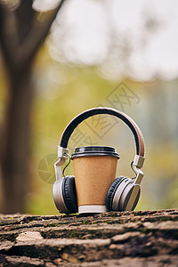 树干上的耳机和咖啡杯图片