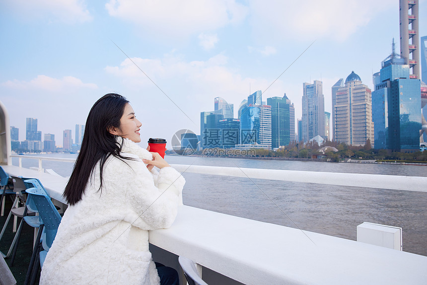 游轮上手捧咖啡杯的旅游女生图片