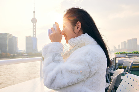 游轮上拿着相机拍照的女生图片