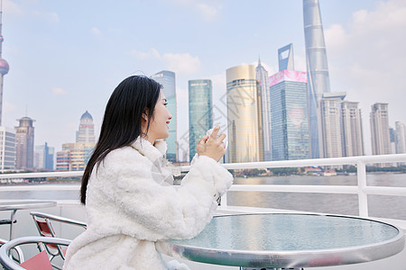 白天在浦江游轮船上拍照打卡的旅游女生背景