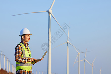 技术工人查看风力发电设备图片