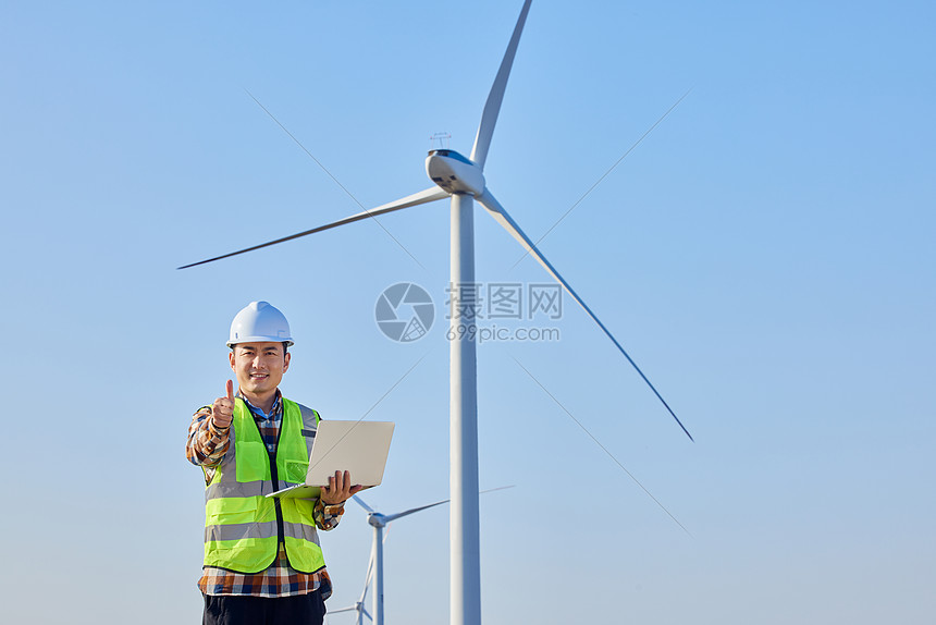 男性工程师勘察风力发电大风车图片