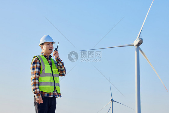 技术工人在风车下拿对讲机指挥图片