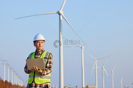 男性工程师勘察风力发电大风车图片