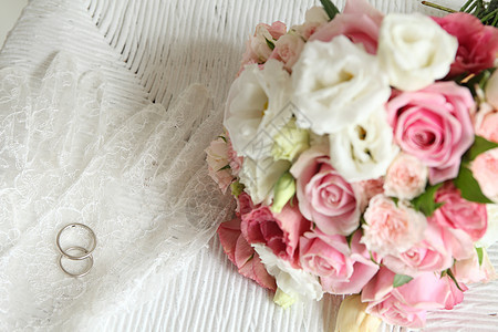 婚纱上婚戒和粉色玫瑰花图片