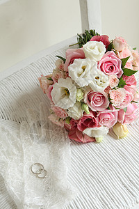 婚纱上婚戒和粉色玫瑰花图片