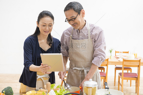中年夫妻看平板电脑学习烹饪方法图片