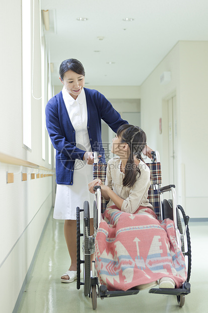 走廊上的护士与轮椅上的小女孩图片