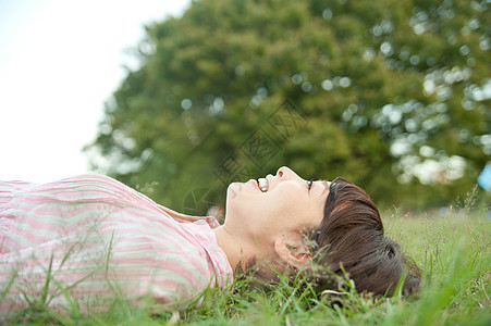 女人躺在公园草地上图片