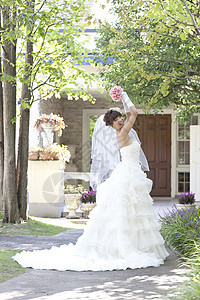 新娘站在花园中扔花束图片