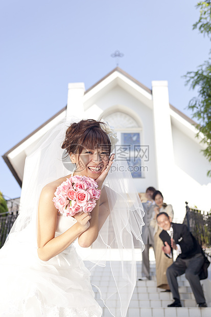 穿婚纱的幸福女人扔手捧花图片